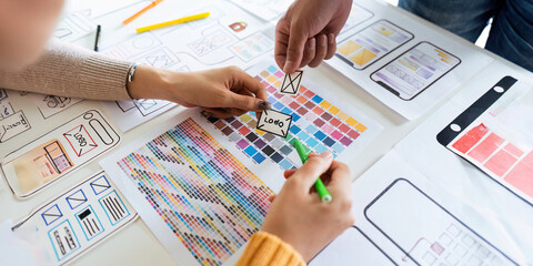 creative digital development agency brainstorming about mobile app interface wireframe design on desk at modern office