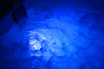 Night shot with copy space of led illuminated jacuzzi pool full of healthy bubbles of water...