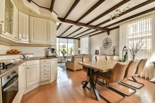 Dining table by kitchen in front of living room at home