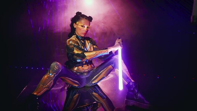Fantasy cyborg woman creative robot costume glowing glasses metal body cyberpunk style braid hairstyle. Sexy alien girl in virtual reality game lady warrior future holding vr laser sword in hands. 4k