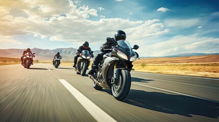 A group of motorcyclists ride sports bikes at fast speeds on an empty road against a beautiful...