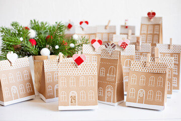 Handmade advent calendar. Houses shaped carton gift boxes. Eco friendly Christmas gifts diy concept