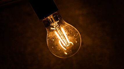 Glowing light bulb on dark background closeup. Finding innovative solution of complicated task...