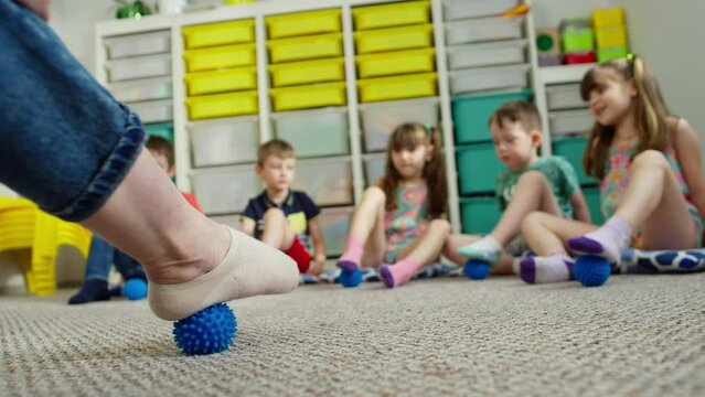 A mobile break with the help of the ball. The teacher shows the children perform. Interaction on nerve endings. High quality 4k footage