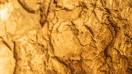 Old textured rocks in wall structure at orange light closeup. Rough boulders with pattern used in building construction works. Stone material put in house foundation at warm light