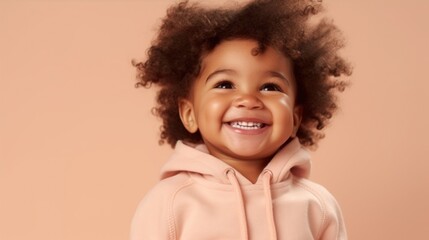 An innocent smile from an African American toddler against a light beige background.