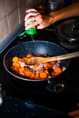 An unrecognizable person is spicing the food.