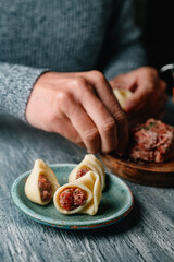 man stuffing some Catalan galets with ground meat