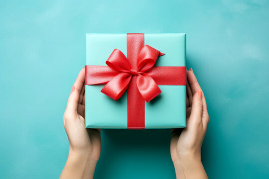 Anonymous famele hands holding a wrapped gift. High quality photo