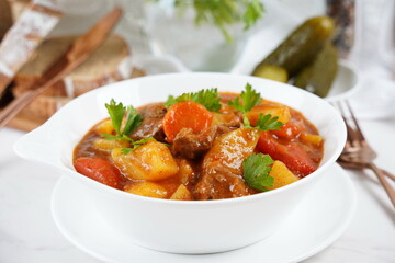 Traditional homemade Hungarian beef meat stew and soup  - Goulash with potatoes, carrots , tomatoes, bell pepper