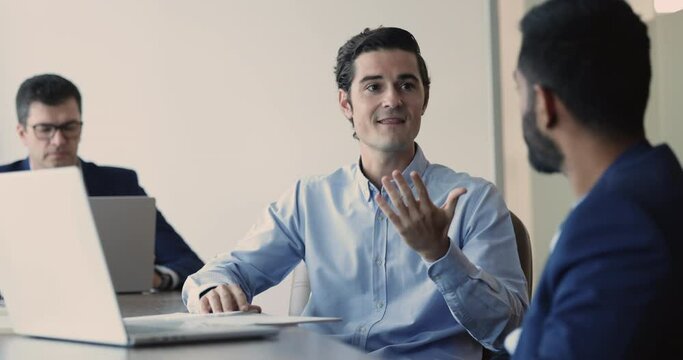 Confident middle-aged Hispanic businessman discussing investment opportunity with financial expert gathered together in office, develop startup ideas, share opinion, consulting with lawyer at meeting