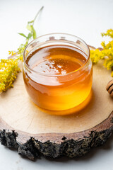Glass jar with liquid floral honey. light table.