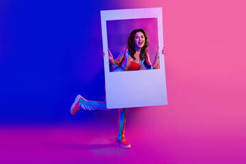 Full length photo of positive carefree person hold paper album set card isolated on multicolor neon...