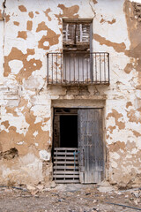 Verfallenes Haus mit verrammelter Tür und einem Balkon