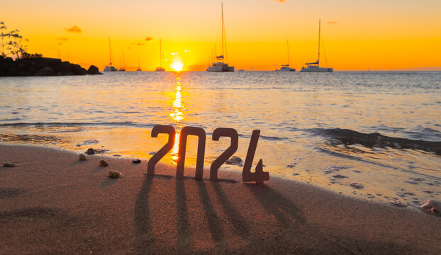 Bonne année 2024 : Concept de nouvelle année 2024 avec un lever de soleil sur une plage des Caraïbes et les chiffres 2024.	