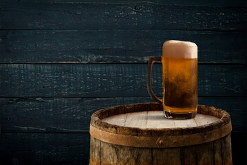 Oktoberfest beer barrel and beer glasses with wheat and hops on wooden table. High quality photo