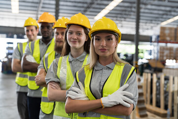 Group of diverse warehouse workers standing with crossed arms in storage warehouse. Team of male...