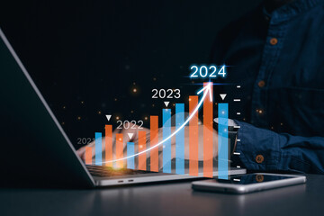 Positive indicators in 2024. Planning and strategy, business development concept.Businessman analyzes profitability of working companies with digital augmented reality graphics - obrazy, fototapety, plakaty