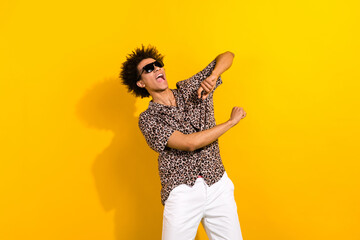 Photo of overjoyed cool guy with afro hair dressed print shirt in sunglass dancing at summer sale isolated on yellow color background