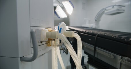 Close up of tubes of life support or lung ventilation machine standing in operating room of modern hospital with advanced equipment for surgery. Bright operating block in clinic or medical facility.