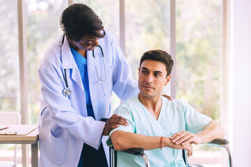 Male patient walking slowly with crutch while nurse supporting at hospital ward.