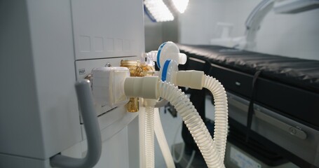Close up of tubes of life support or lung ventilation machine standing in operating room of modern hospital with advanced equipment for surgery. Bright operating block in clinic or medical facility.