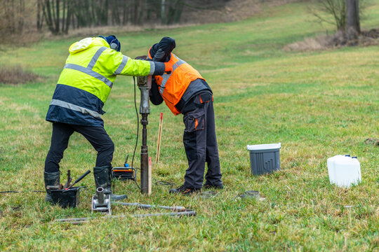 Workers using a soil sampling drill to get a core sample of the ground on a future construction project