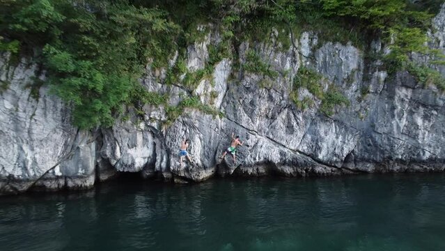 Climbing duo conquering crag over scenic Como Lake, Lecco, Italy