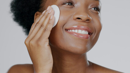 Face, model and hands with pad for cosmetic, beautiful and happiness in facial cleanse in studio background. Black woman, healthy skin and dermatology for self care, spa treatment or aesthetic mockup © Anela R/peopleimages.com