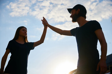 Man and woman, volunteers giving high five. Well-coordinated cooperation. Giving help to people and...