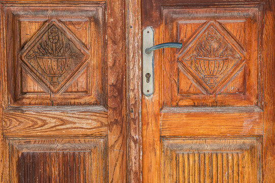 Old vintage wooden door with metal handle close up.