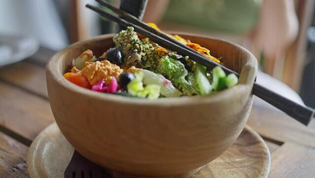 Oriental traditional, Balinese, Vegan salad, served in a wooden plate on a light rustic background. Slow motion