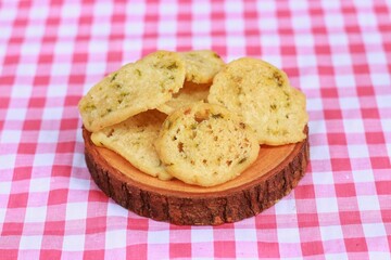 Basreng, Indonesian traditional chip made from fried meatball with chilli powder and lime leaves for seasoning served on wooden plate. Spicy Indonesian chip