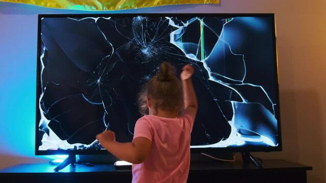 little girl smashing LCD TV screen with hammer. Slow motion