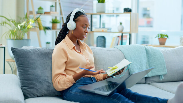 African woman, student and laptop for online course on sofa, headphones and notes with thinking in home. Girl, reading and ideas with notebook, computer or headphones for study on video call on couch - Powered by Adobe