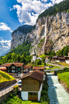 Lauterbrunnen valley with famous church and Staubbach waterfall. Lauterbrunnen village, Berner Oberland, Switzerland, Europe. Spectacular view of Lauterbrunnen valley in a sunny day, Switzerland.