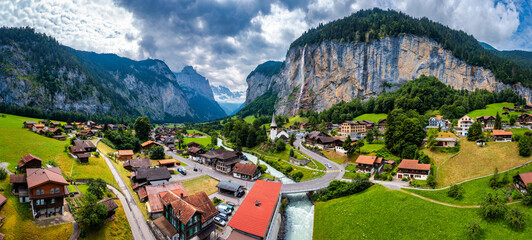 Amazing summer landscape of touristic alpine village Lauterbrunnen with famous church and Staubbach...