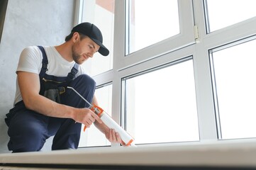 Man putting filling between window and wall in a new house