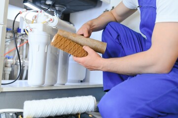 Plumber installs or change water filter. Replacement aqua filter. Repairman installing water filter...