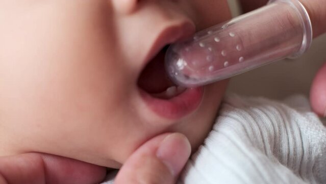 Closeup Shot, Cleaning Asian baby's mouth by brushing his teeth. Baby care, baby's first teeth. Embracing the Concept of Baby Care.