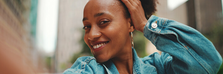 Closeup portret cute African girl with ponytail, wearing denim jacket makes stream, video call on...