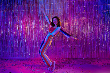 Photo of cheerful positive girl dressed striped overall having fun dancing discotheque isolated...
