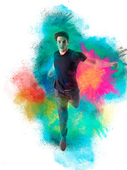 A man in a black shirt is running through colored powder. Photo of a young and attractive man joyfully running through a vibrant cloud of colorful powder