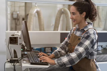 Female factory worker wearing uniform working with desktop computer in industry factory