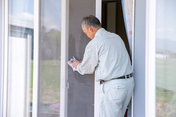 作業着で窓拭きをする男性　window cleaning