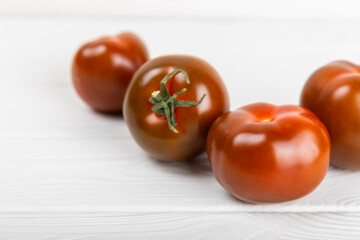Tomatoes on marble texture background. Cherry tomatoes, yellow, pink, brown and black tomatoes in a bowl. Organic vegetables, harvesting.Vegan. Fresh ripe tomatoes. copy space.