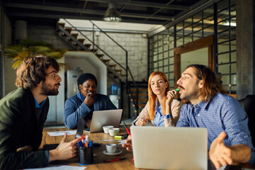 Young and diverse group of designers having a meeting in an office while working in a startup company