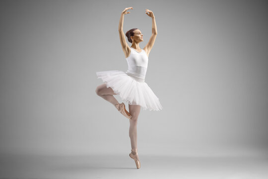 Fototapeta Full length shot of a ballerina in a white dress dancing