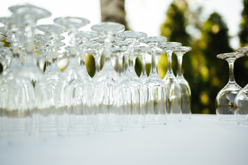 A lot of empty wine glasses. Row of clean glass transparent glasses are on a table on banquet in a bar