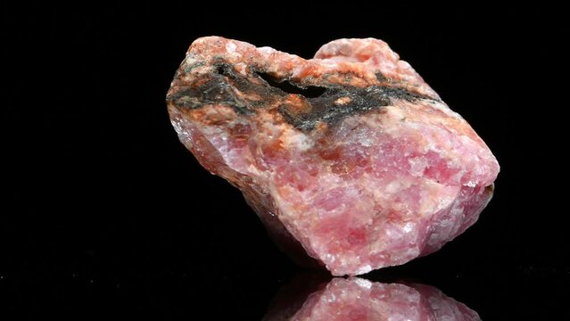 Rhodochrosite (pink Manganese carbonate) specimen rotating slowly against a black background.